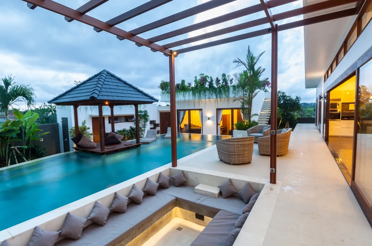 Luxurious poolside villa with outdoor seating area.