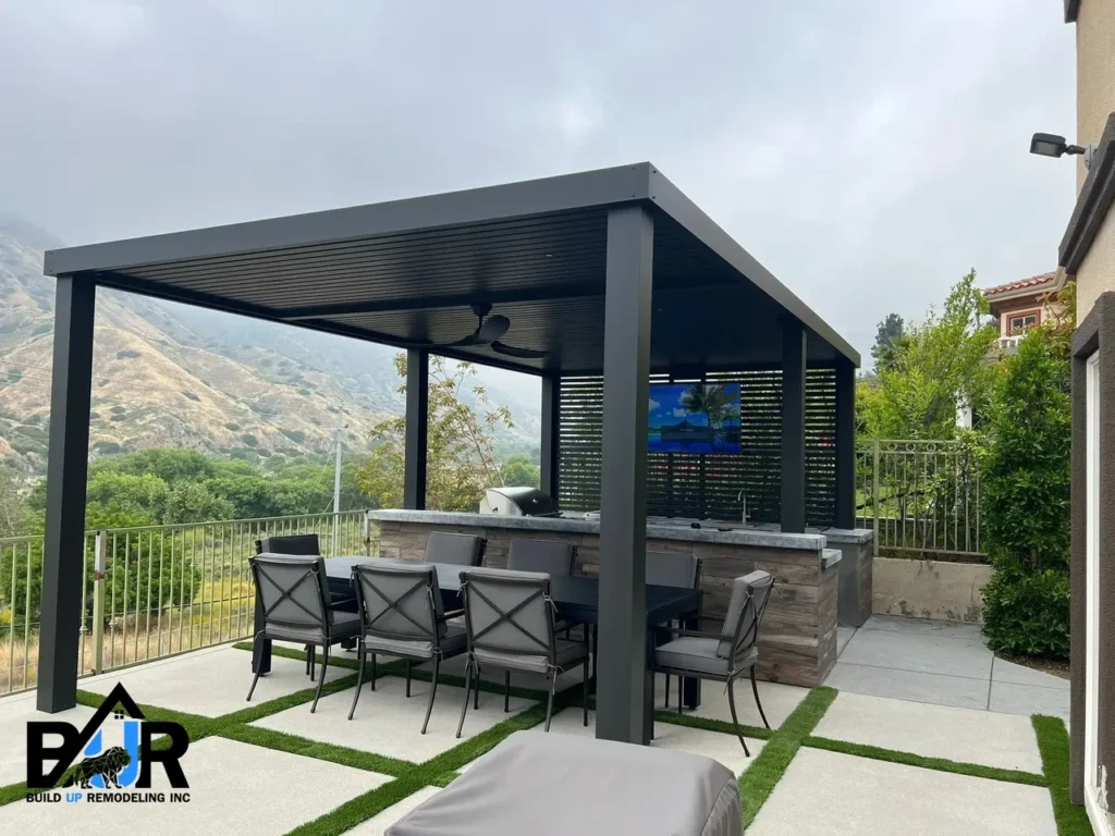 Modern outdoor kitchen with bar seating under a pergola.