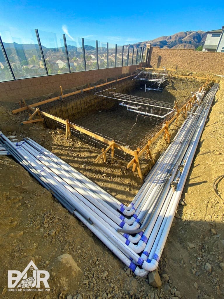 Construction site with exposed pipes and foundation.