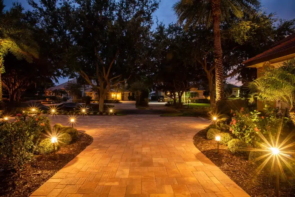 Driveway lighting design highlighting pavers and landscape features at night
