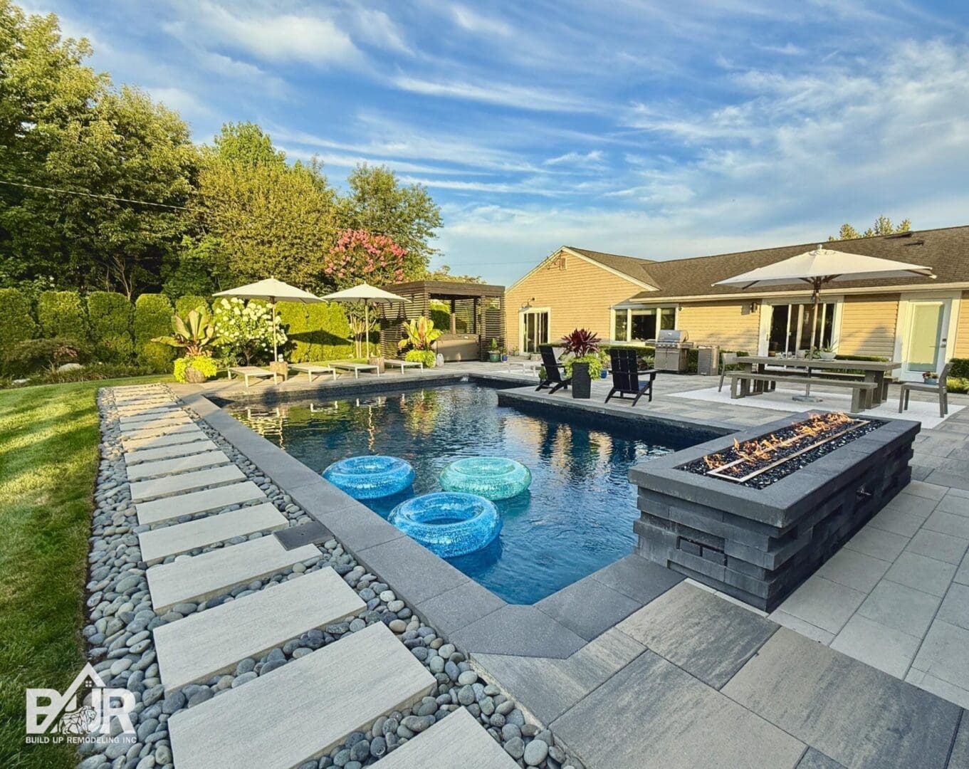 Modern backyard pool with patio and firepit.
