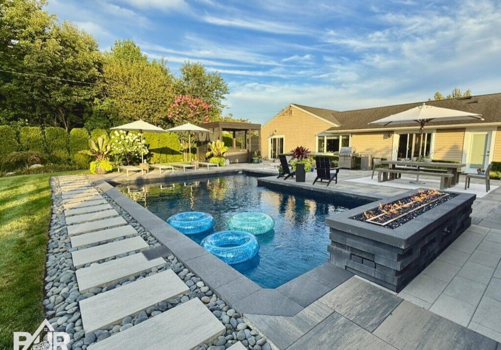 Modern backyard pool with patio and firepit.