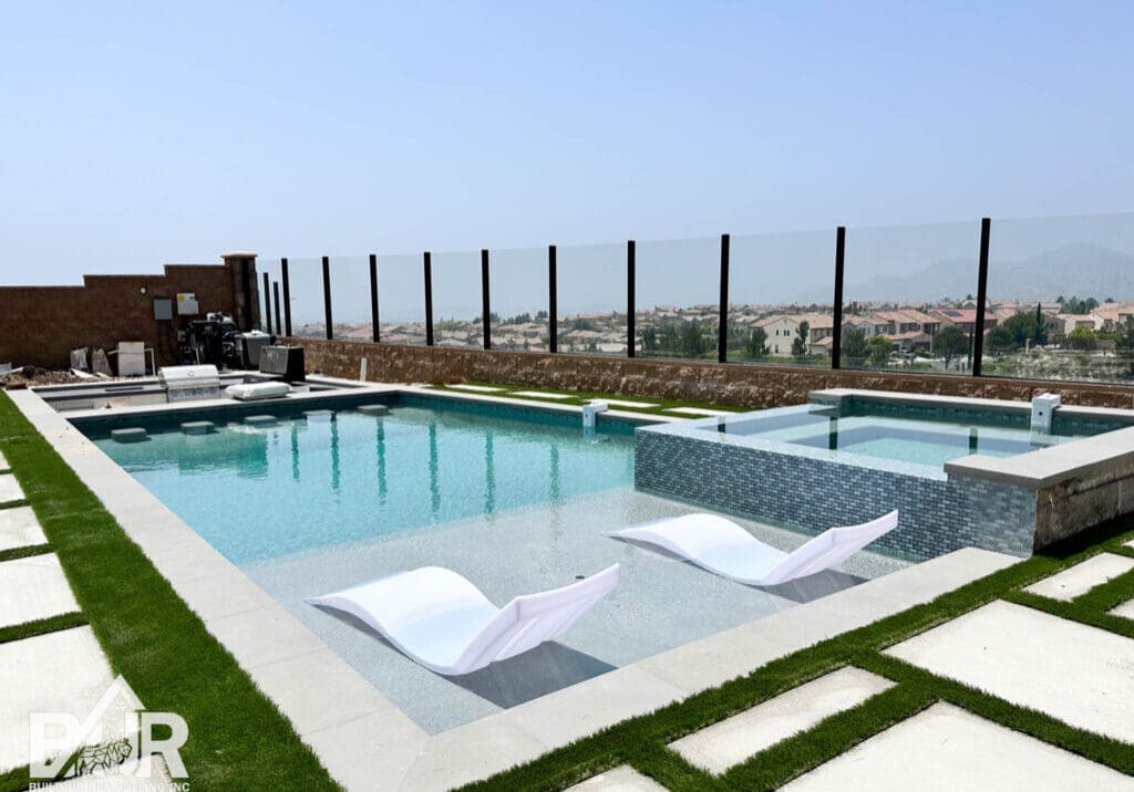 Rooftop pool with lounge chairs and view.