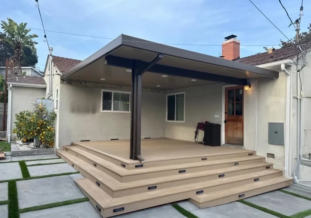 Covered patio with steps and concrete pathway.
