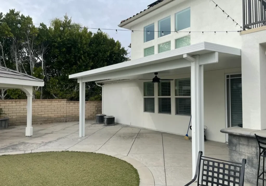 Modern patio with white pergola and chairs.